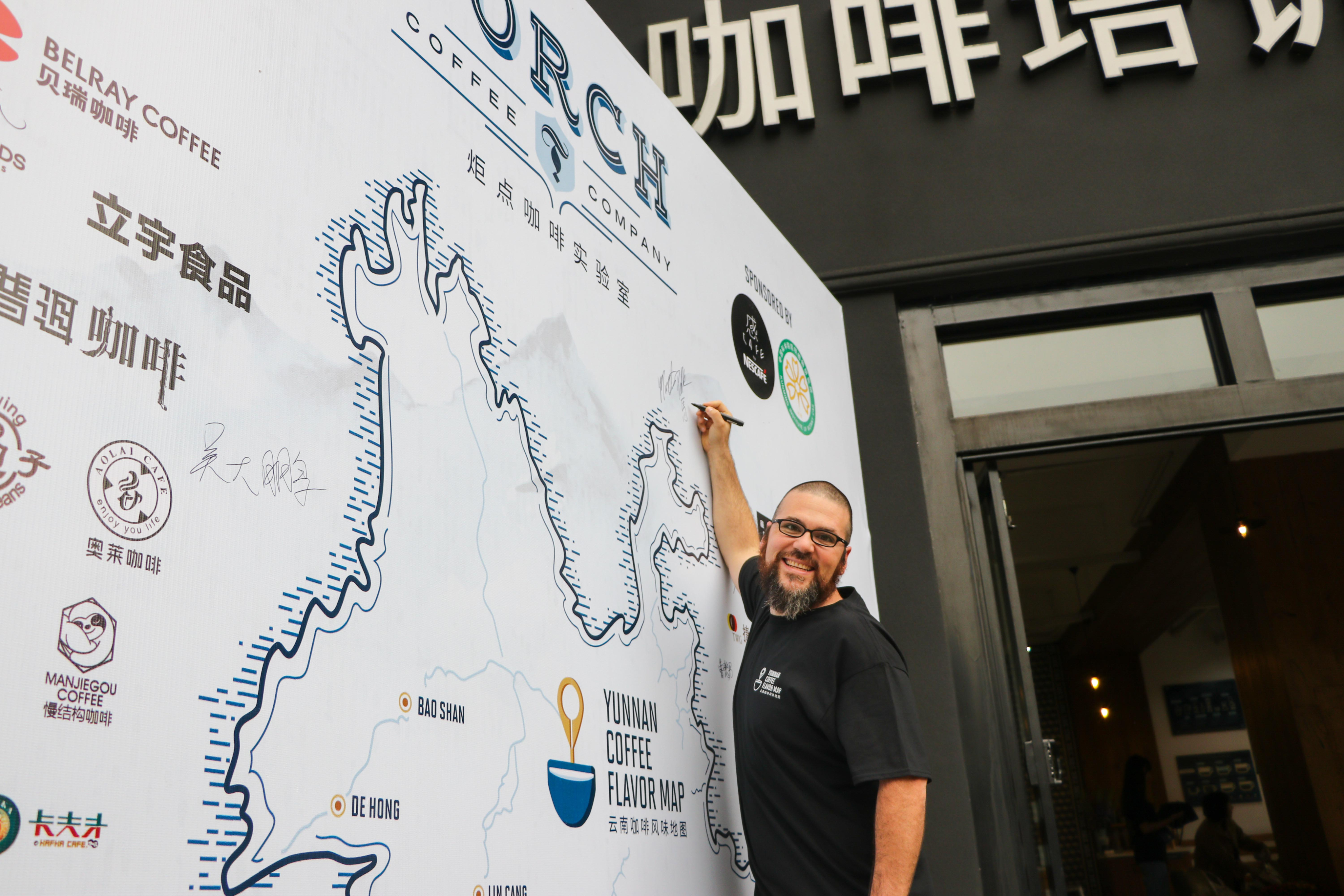 Person pointing at a large coffee flavor map on a wall